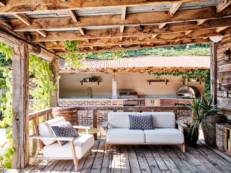 Sheltered seating beneath a timber pergola and climbing vines